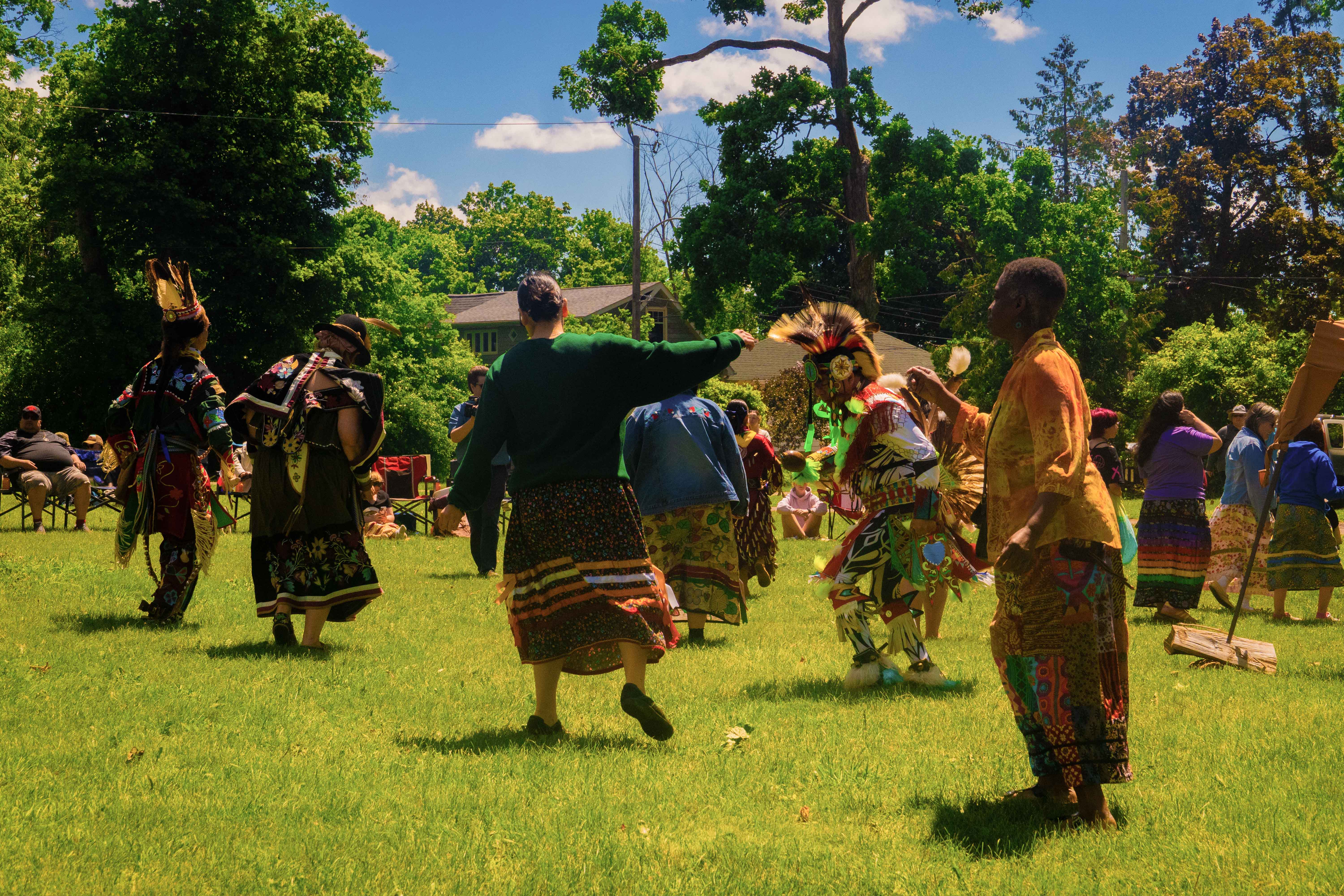 Community members participating in an Indigenous cultural gathering outdoors