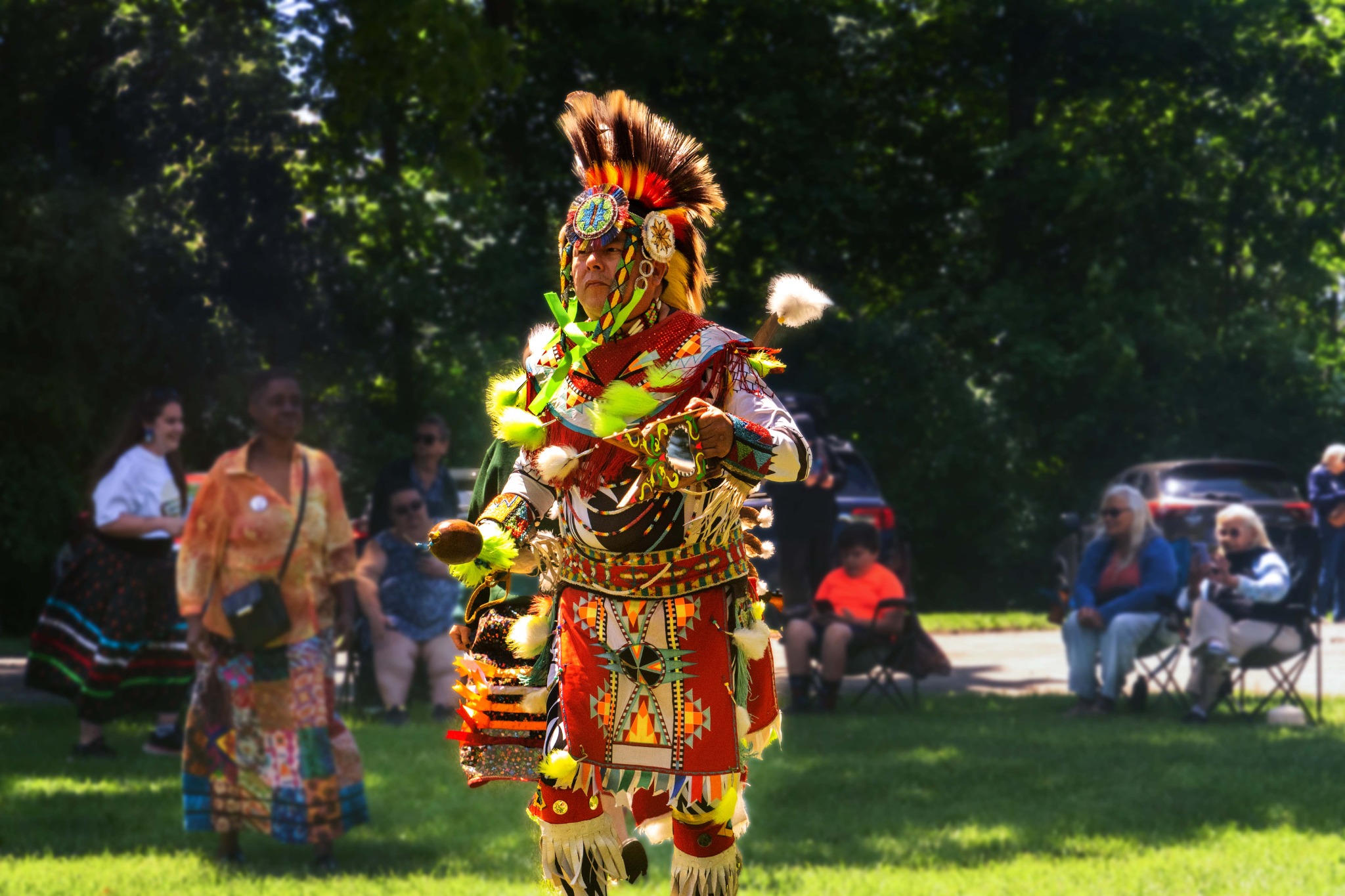 Indigenous dancer in detailed regalia during an outdoor community gathering